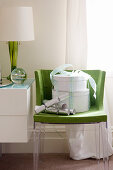 Two white hatboxes and Christmas crackers on green chair