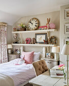 Shelves of toys and large clock above bed in girl's room