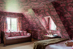 Attic style bedroom with bold toile de jouy wallpaper and fabric