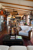 Rustic open-plan living room with sloping wood-beamed ceiling