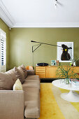 Sofa, sideboard and classic table in the living room with green walls