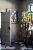 Stehlampen und Zimmerpflanze vor Gemälde in Zimmerecke mit bemaltem Dielenboden