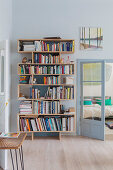 Modern bookcase next to double doors leading into bedroom