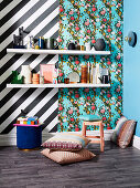 White shelves with decorative objects in front of black and white striped wallpaper and in front of floral wallpaper