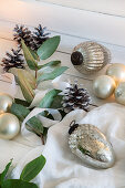 Christmas-tree baubles, pine cones and leafy branches