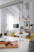 Weiße Küchentheke im Hintergrund runder Tisch mit Stühlen