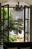 View through open window into courtyard with designer Butterfly chairs