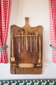 Wooden board repurposed to store kitchen utensils