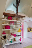 Stairs and shelves leading to gallery in child's bedroom with brightly coloured accessories