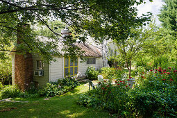 Idyllic cottage with chimney in summery garden