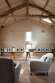 Gallery of artworks and seating area in renovated barn converted into workshop studio