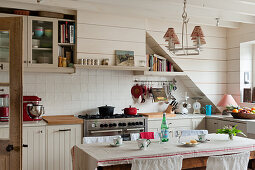 Küche im Landhausstil mit weiß gestrichenen Holzwänden