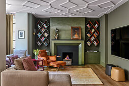 Armchair and footstool next to fireplace and diamond-shaped bookshelves in TV room
