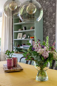 Vase of summer flowers in vintage-style dining room