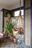 Old mosaic floor and bamboo hanging chair with fur blanket in conservatory