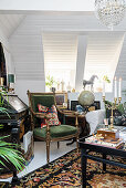 Opulently decorated attic room with bureau and green armchair