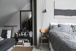 Schlafzimmer in Grau mit Sofa unter der Dachschräge