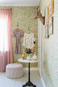 Cat pegs, hunting trophy and pictures on floral wallpaper