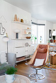 Retro armchair in front of String shelving in Scandinavian-style living room