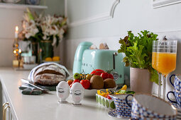 Frühstückseier, Brot, Saft, Obst und Geschirr auf der Küchenarbeitsplatte