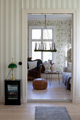 Suspended wreath, sofas and floral wallpaper in living room