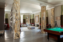 Pool table in open-plan interior with marble pillars