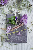 Linen napkin folded into cutlery pouch, hyacinths and violas