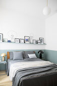 Picture ledge on two-tone wall in minimalist bedroom with clean lines