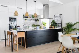 Black kitchen counter and table combo in modern kitchen-dining room