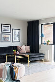 Black, velvet chaise sofa, brass coffee table and pink pouffe in living room