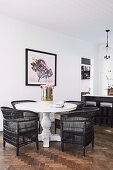 Black wicker chairs on white baluster table on herringbone parquet