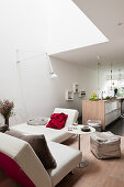 Kitchen and white, modular sofa in open-plan interior of architect-designed house