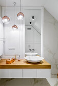Waschtisch mit Aufsatzbecken in elegantem Bad mit Marmorwand