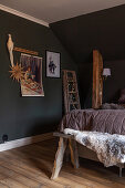Festive decorations in rustic bedroom with sloping ceiling and dark walls
