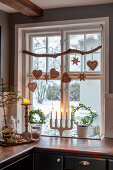 Gingerbread hearts and stars hung from branch in window