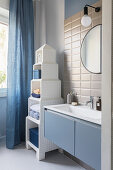 Tower-style shelves in bathroom in blue and white with subway tiles