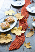 Rusty-red leaf-shaped hand-knitted coasters for decorating autumnal table