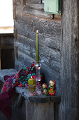 Handbemalte Glaskerzenhalter und traditionelle Matrjoschka auf Holzbank