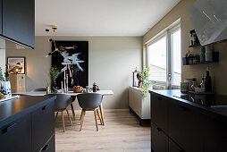 Open-plan kitchen with black cabinets and dining room in earthy shades