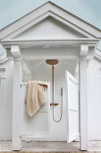 Outdoor shower with saloon doors and porch roof