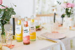 Various bottles of lemonade on festively set table