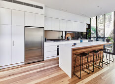 Große moderne Küche mit Holzboden, Kücheninsel und Fensterfront