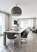 Upholstered chairs around dining table in interior in shades of grey and white