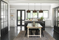 Dining area and industrial-style glass sliding door as partition in open-plan kitchen