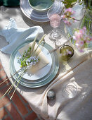 Blumen, Ähren und ein Umschlag auf dem Teller des gedeckten Tischs
