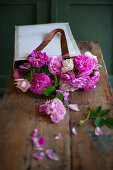 Pink roses in paper bag on wooden table