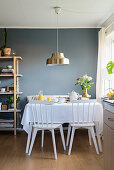 Gedeckter Frühstückstisch vor blaugrauer Wand im Esszimmer