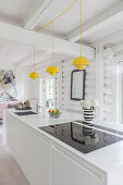 Gelbe Klassikerlampen über weißer Kücheninsel