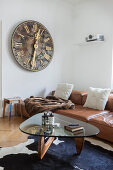 Old church clock face, leather sofa and designer table