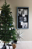 Christmas tree next to collage of photos on wall